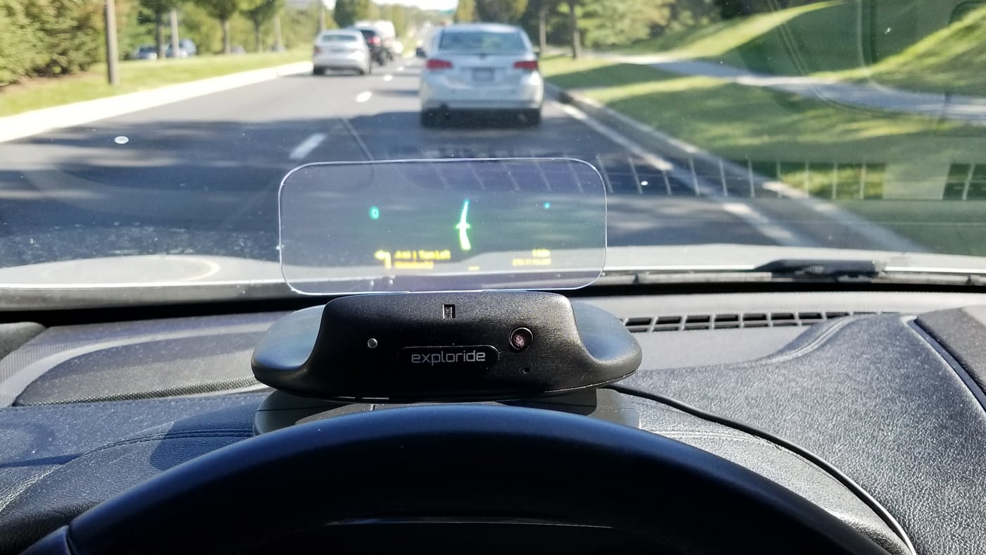 Exploride hardware mounted on a dashboard, projecting navigation onto its transparent head-up display